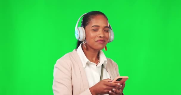 Dance, green screen and woman with headphones and cellphone for music, playlist or album in studio. Happy, technology and female model dancing and streaming a song isolated by a chroma key background. - Footage, Video
