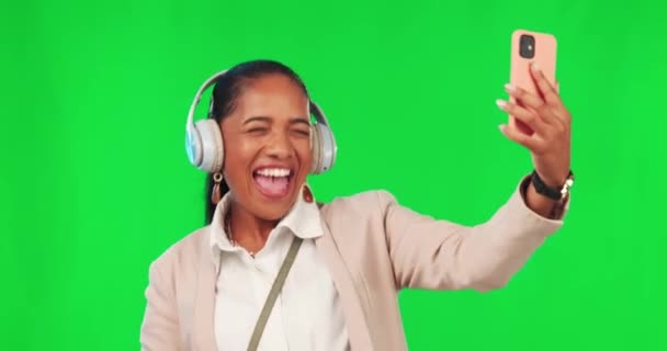 Green screen, woman and dance with music, headphones and phone, happy on studio mockup background. Radio, earphones and female dancing to podcast on smartphone app, smile and celebrating freedom. - Footage, Video