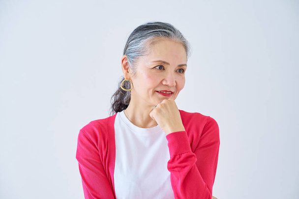 Uma mulher idosa com uma expressão duvidosa dentro de casa - Foto, Imagem