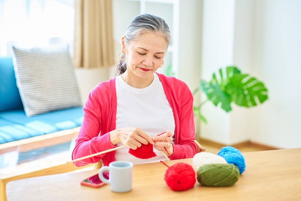 Senior žena těší pletení příze v místnosti - Fotografie, Obrázek