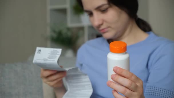 Une femme lit les instructions pour un médicament à la maison. - Séquence, vidéo