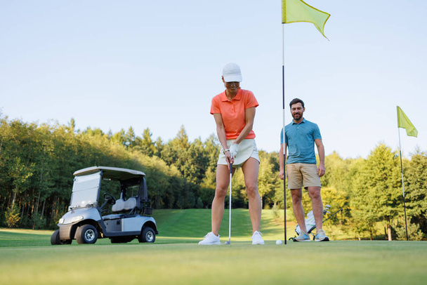 Strategiczne uderzenie: kobieta Golf Swing na Final Hole - Zdjęcie, obraz