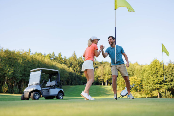 Zwycięska kobieta świętuje Golf Wygraj z partnerem - Zdjęcie, obraz