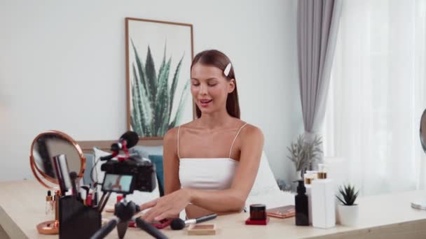 Young woman start live streaming beauty and cosmetic tutorial video content for social media. Beauty blogger smiles to camera while showing how to beauty care to audience or followers. Adit - Footage, Video