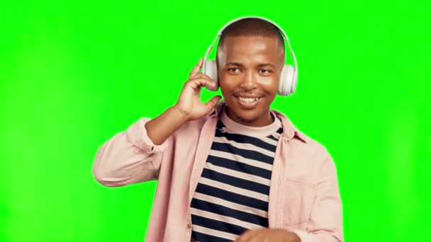Słuchawki muzyczne, taniec i czarny człowiek na zielonym ekranie w studio izolowane na tle. Radio, słuchanie i szczęśliwa afrykańska osoba tańcząca do audio playlisty, podcastu jazzowego lub strumieniowego hip-hopu - Materiał filmowy, wideo