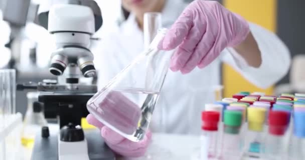 Cientista segurando frasco cônico com líquido claro em close-up laboratório. Pesquisa do conceito de filtros de água - Filmagem, Vídeo