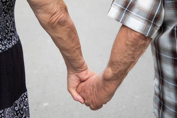 Οι παππούδες κρατιούνται χέρι. Οι επιλογές των ανθρώπων επικεντρώνονται - Φωτογραφία, εικόνα