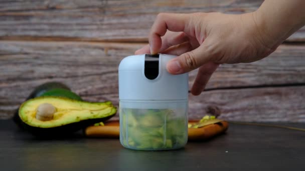 Pulsante di pressione mano maschile sul frullatore di avocado - Filmati, video
