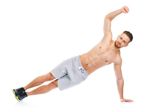 Спортивний привабливий чоловік робить фізичні вправи на білому
 - Фото, зображення