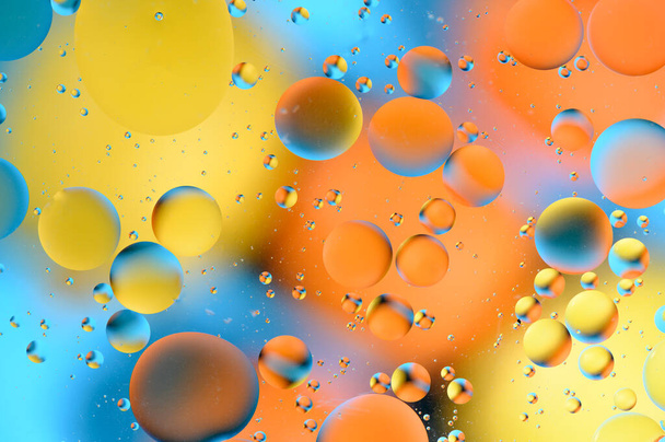 голубые и оранжевые пятна с разноцветными кругами, похожими на галактику и микрокосм 1 - Фото, изображение