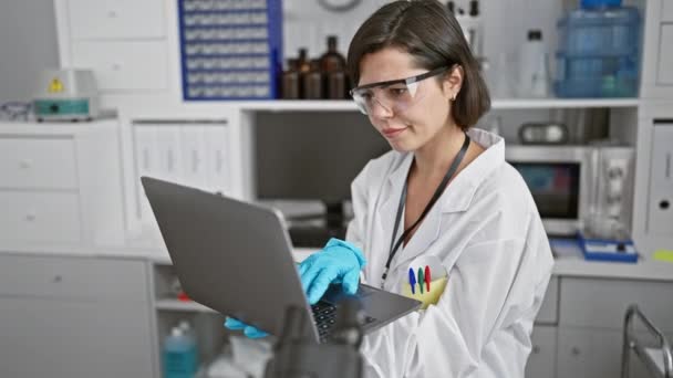 Присвячена молода іспаномовна жінка-науковець, зосереджена на ноутбуці в лабораторії, частина нової хвилі красивого таланту в медичних дослідженнях - Кадри, відео