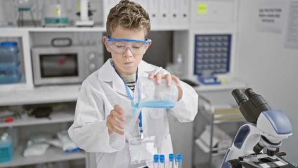 Blond jongen wetenschapper gieten vloeistof in het laboratorium - Video