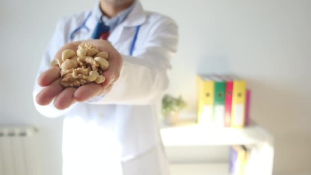 lékař drží srdeční model a ořechy na rukou v nemocnici, lékařské a zdravotní koncepce - Záběry, video