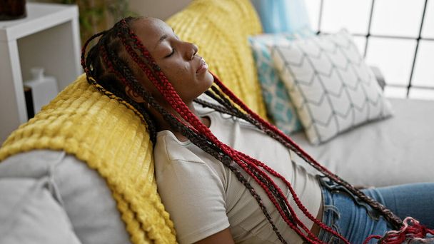 Mulher afro-americana exausta encontra conforto dormindo em seu sofá acolhedor, relaxando em casa depois de um longo dia - Foto, Imagem