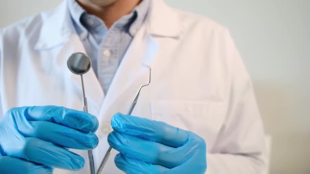 médico masculino sosteniendo herramientas de odontología  - Imágenes, Vídeo