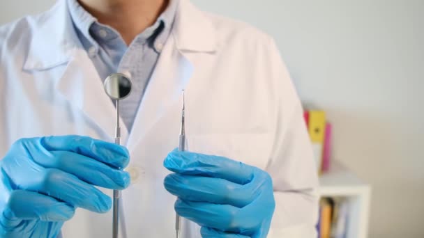 médico masculino sosteniendo herramientas de odontología  - Metraje, vídeo
