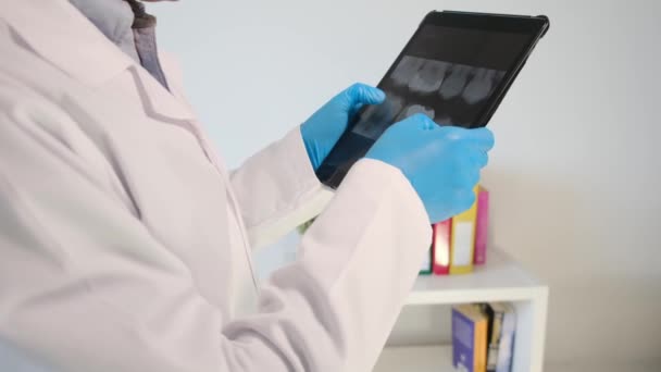 крупным планом руки стоматолога, держащего планшетный компьютер с рентгеновским снимком зубов - Кадры, видео