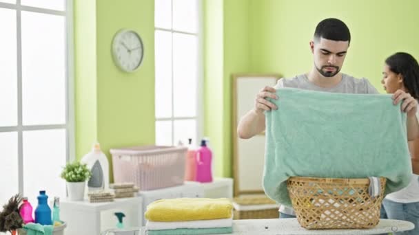 Mooi koppel samen doen wasklusjes binnen, sms 'en op smartphone, nippen koffie in de wasruimte - Video