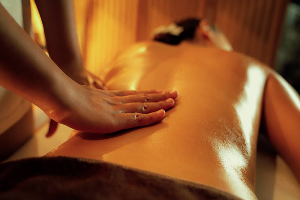 Close-up vrouw klant genieten van ontspannende anti-stress spa massage en verwennerij met schoonheid huid recreatie vrijetijdsbesteding in warme kaars verlichting ambient salon spa in luxe resort of hotel. Stil maar. - Foto, afbeelding