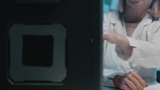 Colaboradores em casacos brancos sentados em instalações médicas revisando parte recém-feita de seu projeto por máquina de impressão 3d - Filmagem, Vídeo