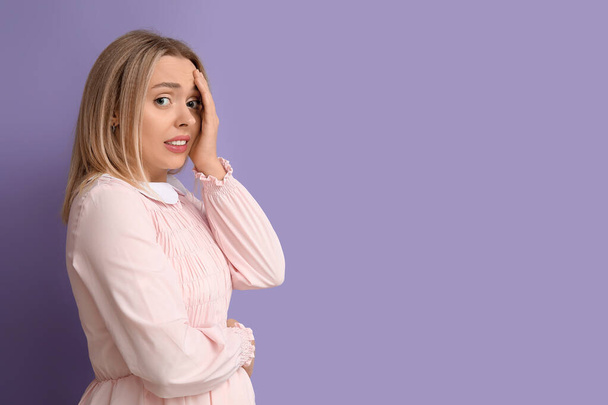 Imbarazzato giovane donna su sfondo lilla - Foto, immagini