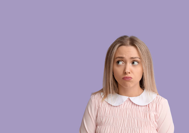 Imbarazzato giovane donna su sfondo lilla - Foto, immagini