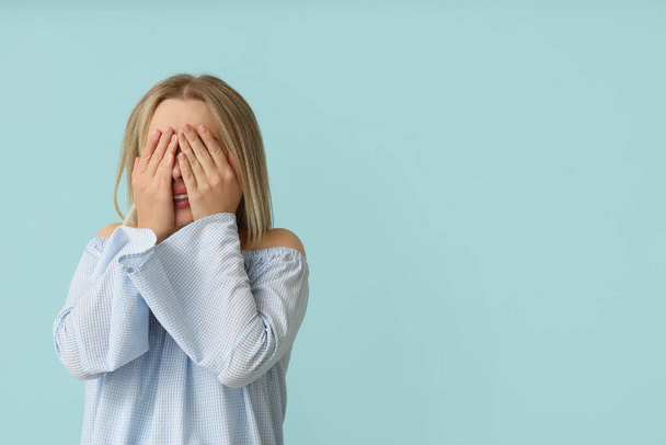 Embarrassed young woman on blue background - Photo, Image