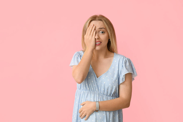Mujer embarazada avergonzada sobre fondo rosa - Foto, imagen