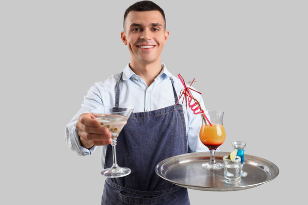 Молодий чоловічий бармен з коктейлями на білому тлі - Фото, зображення