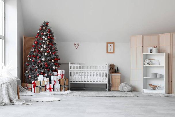 Süslü Noel ağacı ve hediye kutularıyla dolu bir bebek odası. - Fotoğraf, Görsel