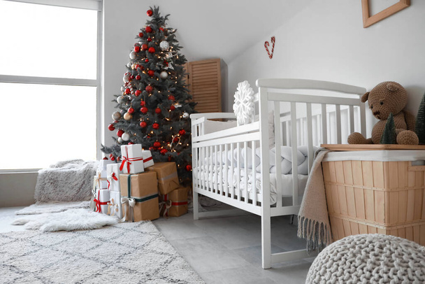 Interior de la habitación del vivero festivo con árbol de Navidad decorado y cajas de regalo - Foto, Imagen
