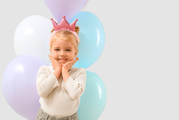 Χαριτωμένο κοριτσάκι με όμορφα μπαλόνια σε γκρι φόντο - Φωτογραφία, εικόνα