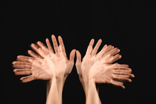 Stroboskopisches Foto bewegter weiblicher Hände auf dunklem Hintergrund - Foto, Bild