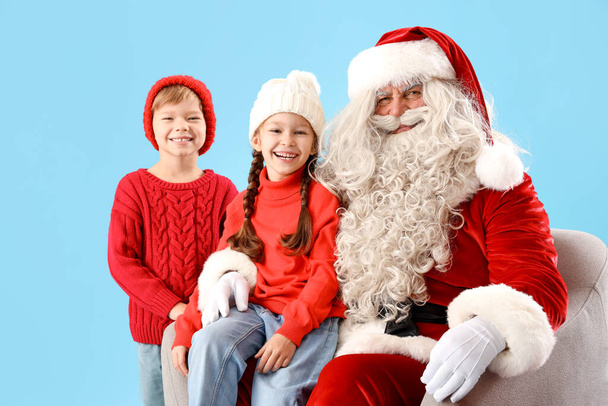 Petits enfants avec le Père Noël sur fond bleu - Photo, image