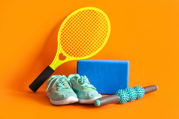 Verschillende sportuitrusting op oranje achtergrond - Foto, afbeelding