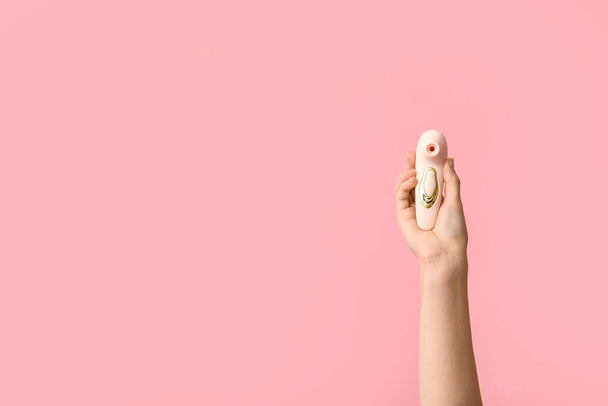 Weibliche Hand mit Vibrator auf rosa Hintergrund - Foto, Bild