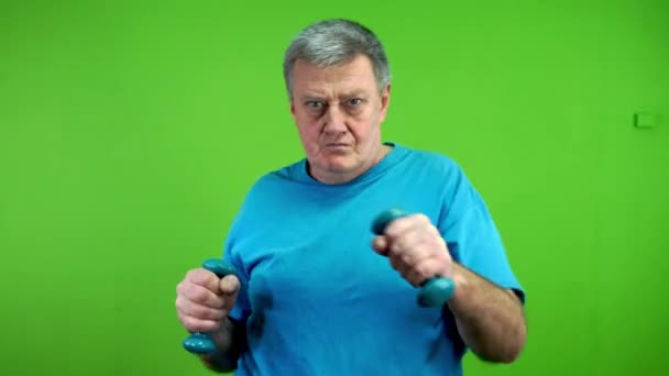 Senior man doing dumbbells exercise daily workout, boxing in front of himself. Mature person doing sport or exercise for maintaining health. Green screen. Chroma key. - Footage, Video