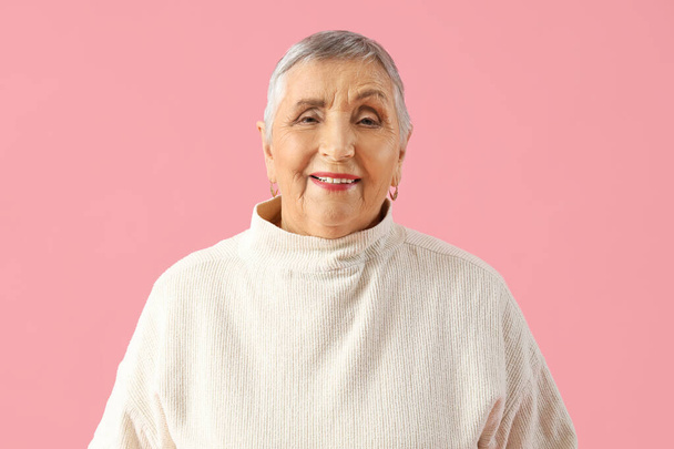 Senior vrouw op roze achtergrond, close-up - Foto, afbeelding