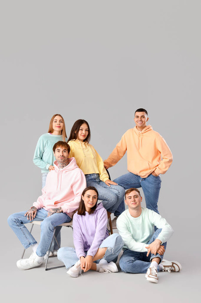 Группа молодых людей в стильных джинсах на светлом фоне
 - Фото, изображение