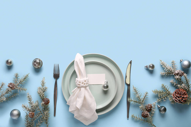 Piękne ustawienie stołu z gałązek jodły, kulki świąteczne i szyszki sosny na niebieskim tle - Zdjęcie, obraz