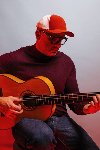 Erwachsener Mann spielt Gitarre im Studio. - Foto, Bild