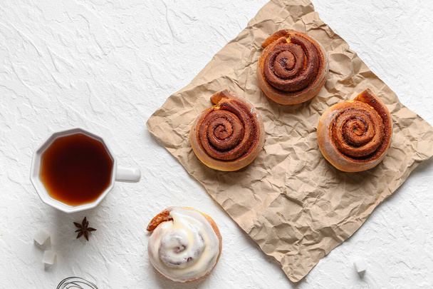 Tasty cinnamon rolls and cup of tea on white background - Photo, Image