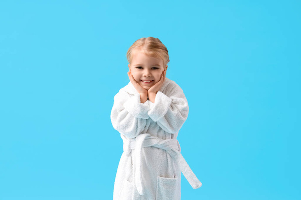 Симпатична дівчинка в халаті на синьому фоні - Фото, зображення