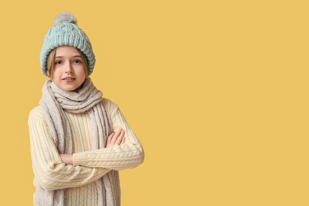 Cute little boy in winter clothes on yellow background - Photo, Image