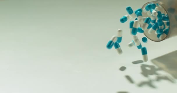 Fármacos, pastillas derraman y medicamentos en contenedores en un estudio con fondo blanco y cápsula. Medicamentos, productos farmacéuticos y tabletas de prescripción para el bienestar y la salud con suplementos médicos. - Metraje, vídeo