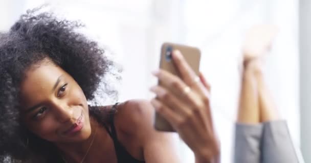 Selfie, rilassarsi e felice donna nera sul letto per post sui social media, aggiornamento e influencer blog. Networking, camera da letto e persona femminile sorridono scattando foto per app mobile, internet e sito web a casa. - Filmati, video