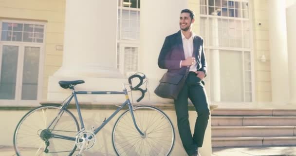 Bicycle, relax and business man waiting, happy and smile for transport, outdoor commute or city journey. Bike transportation travel, cycling manager and urban person leaning on office building wall. - Footage, Video