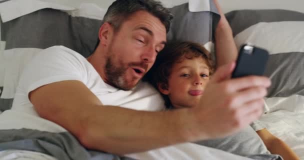 Crazy, selfie and father with child in a bed happy, bond and embrace in their home. Silly, face and kid with parent in a bedroom with goofy expression for photo, memory or profile picture indoors. - Кадри, відео