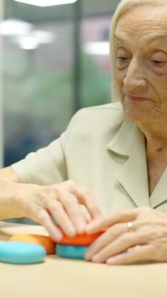 Βίντεο μιας ηλικιωμένης γυναίκας που παίζει παιχνίδια δεξιοτήτων με στρογγυλά κομμάτια στη γηριατρική - Πλάνα, βίντεο