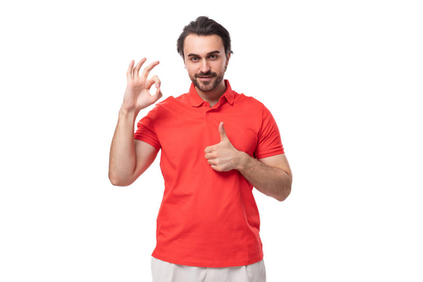 mladý úspěšný 35 letý Evropan muž se stylovým účesem a vousy oblečený v červeném rovném tričku na bílém pozadí s kopírovacím prostorem. - Fotografie, Obrázek